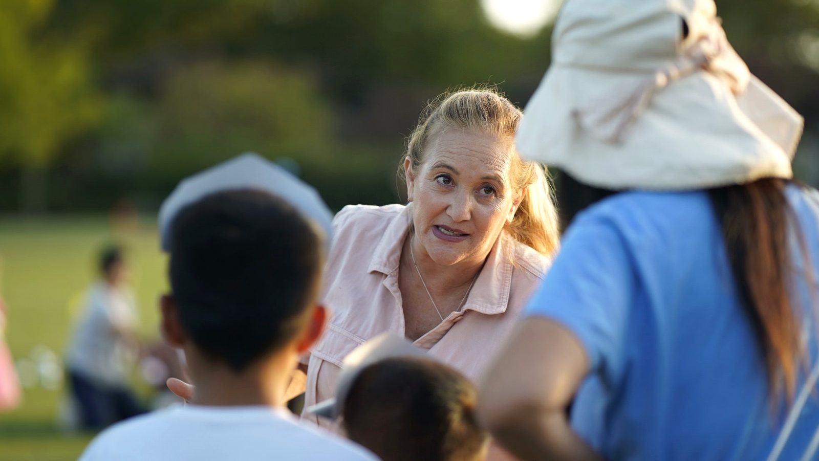 An adult leaning in and connecting with children at a community event
