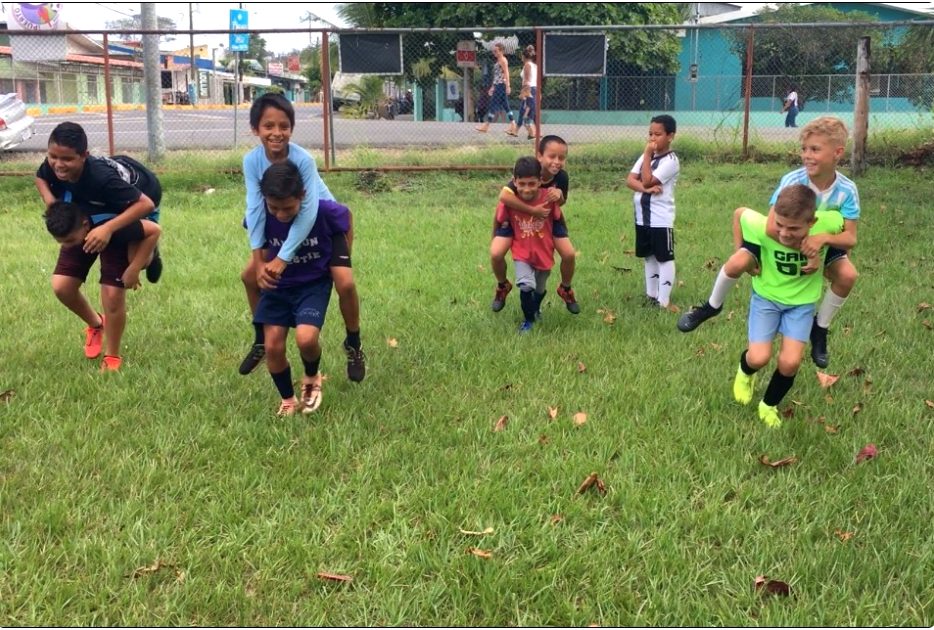 Children playing together in an open field during the Costa Rica Play Pilgrimage