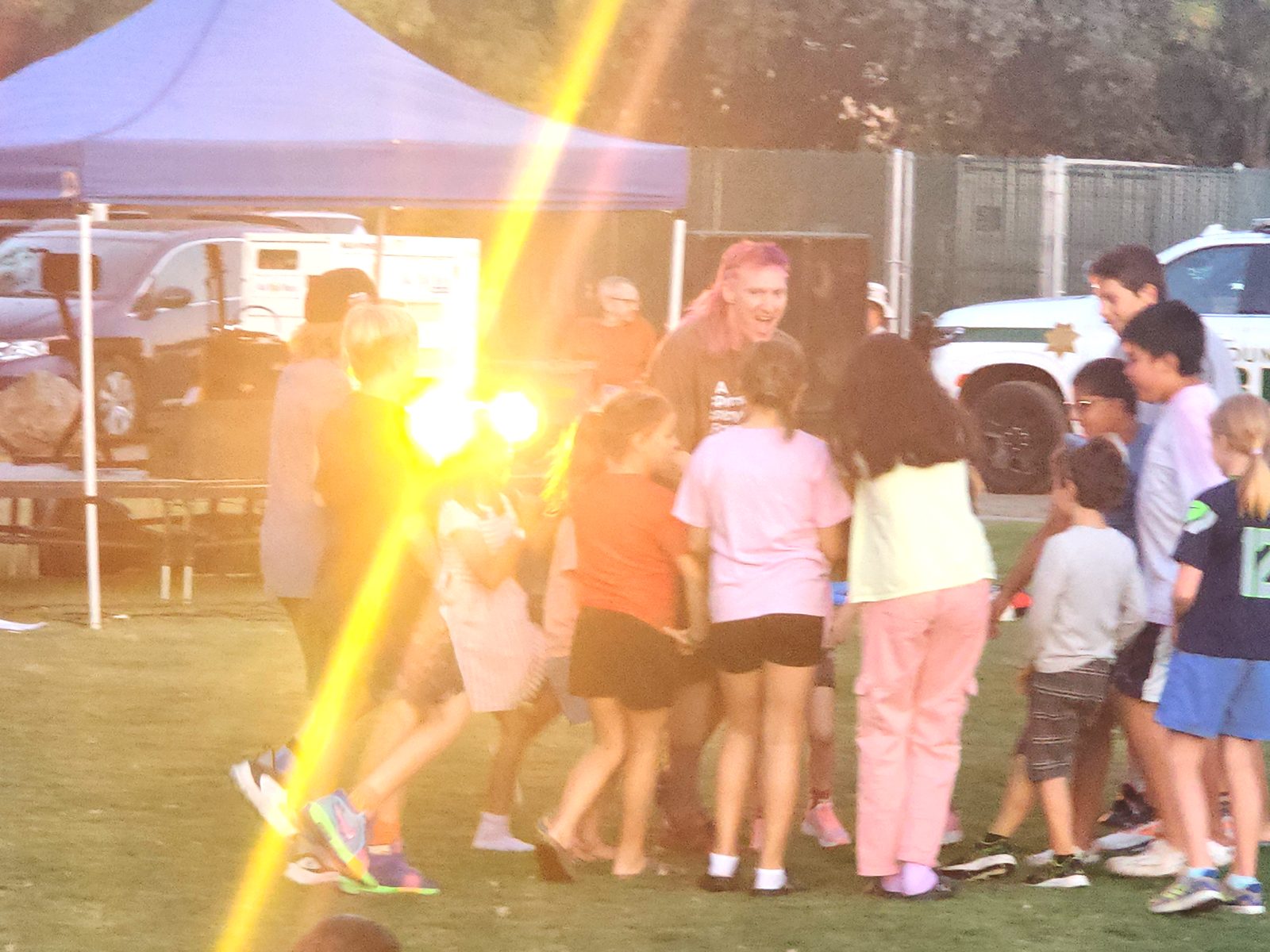 Jared Hippler leading a big circle of laughing kids in a play game at the Family Fun Fest